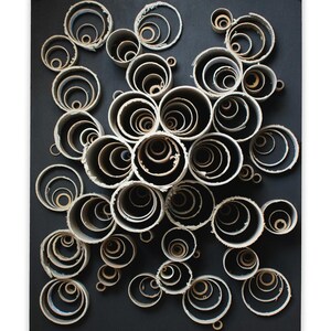 Obra de arte reciclada Tubos de cartón sobre pizarra mate