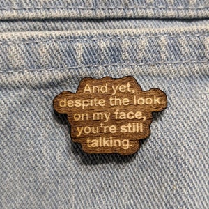 Könnte beinhalten: Ein Holzstift mit dem Text "And yet, despite the look on my face, you're still talking."