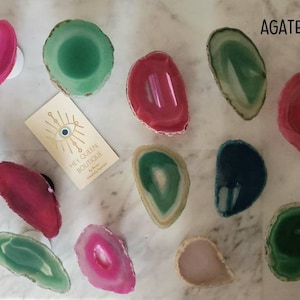 May include: A set of three ceramic mugs with a speckled, matte finish. The mugs are in shades of cream, light brown, and dark brown. Each mug has a simple, minimalist design and a rounded handle.