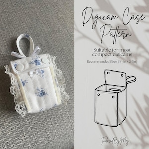 May include: A white fabric case with blue floral print and white lace trim. The case is designed to hold a small camera. The case is closed with a white button and has a white ribbon bow. The image also includes a line drawing of the case pattern. The text on the image reads "Digicam Case Pattern", "Suitable for most compact digicams", "Recommended Sizes (3-4in x 2 3in)", and "Tailored By Meg".