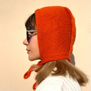 Hand knitted orange bonnet made from 100% merino wool