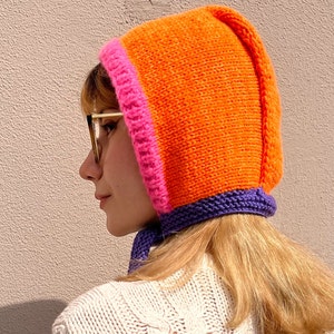 Hand knit adult’s bow tie bonnet in hot orange, pink and purple