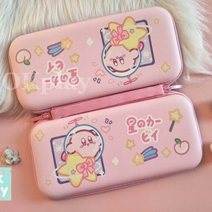 Puede incluir: Estuche de transporte rosa para Nintendo Switch con un dise&ntilde;o de personaje de dibujos animados que presenta un personaje rosa con una estrella y un melocot&oacute;n. El estuche tiene texto japon&eacute;s que dice "星のカーヒイ" que se traduce como "Kirby's Star".