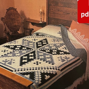 May include: A black and white quilt with a geometric pattern is on a wooden bed frame. The quilt is made with a variety of fabrics, including cotton and linen. The bed is dressed with a white sheet and a pillow with a lace trim.