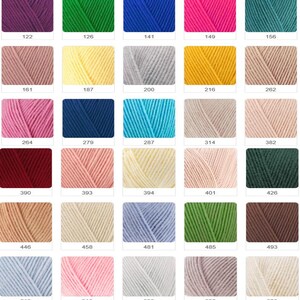 May include: A collection of yarn skeins in various colors, including orange, gray, pink, green, and yellow. Each skein is labeled with a number, such as 83, 87, and 98. Ideal for knitting and crochet projects.