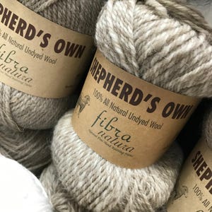 May include: Two skeins of natural undyed wool yarn labeled "Shepherd's Own" with the text "100% All Natural Undyed Wool" and "fibra natura".