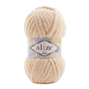 May include: A skein of beige yarn with a label that reads "BABY alize Softy Mega".