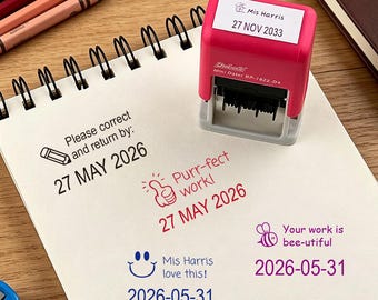 May include: A pink self-inking dater stamp with a white label reading Mis Harris 27 NOV 2033. The stamp sits on a spiral notebook showing ink impressions: Please correct and return by: 27 MAY 2026, Purr-fect work! 27 MAY 2026, Mis Harris love this! 2026-05-31, and Your work is bee-utiful 2026-05-31.
