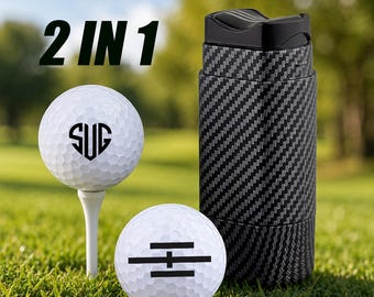 May include: A 2 IN 1 set featuring two white golf balls and a black carbon fiber patterned cylindrical container. One golf ball sits on a white tee and displays the letters SUG in a heart shape, while the other ball features a black horizontal line graphic.
