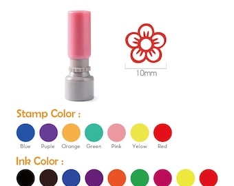 Puede incluir: Un sello autoentintable con mango rosa y base gris, que presenta un diseño de flor de 10 mm. La imagen muestra una selección de siete colores para el cuerpo del sello y ocho opciones de color de tinta, incluyendo negro, marrón, azul, morado, naranja, verde, rosa, amarillo y rojo.