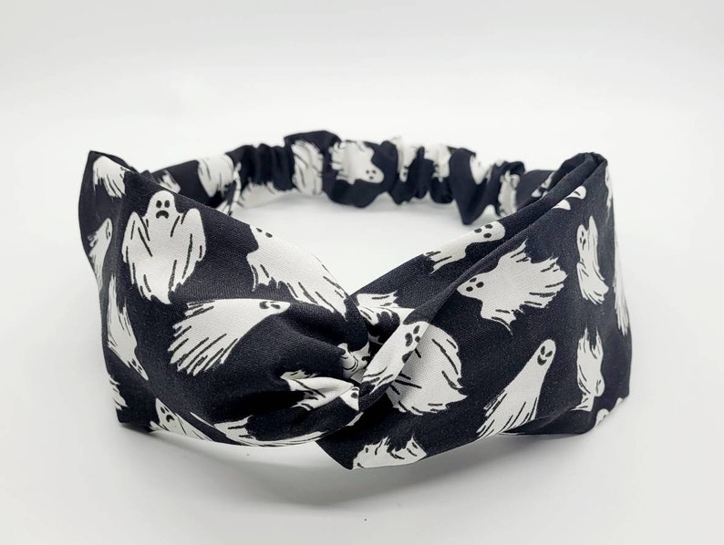 May include: Black and white knotted headband with a ghost pattern.