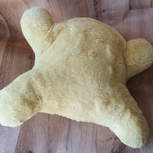 May include: A yellow plush pillow shaped like a star. The pillow is soft and fluffy, and it would be perfect for cuddling.