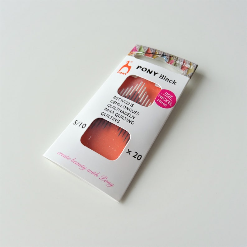 May include: A package of 20 black quilting needles, size 5/10, by Pony. The package is white with pink and orange accents. The text on the package reads "Pony Black" and "create beauty with Pony".