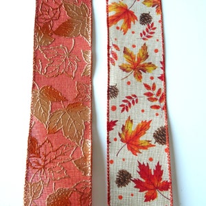 May include: Two rolls of autumn-themed ribbon. One roll is orange with gold metallic leaves. The other roll is beige with orange and red leaves.