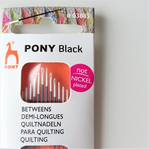 May include: A package of PONY Black quilting needles. The package is white with orange and pink accents. The needles are not nickel plated. The package includes the text "PONY Black" and "not nickel plated".