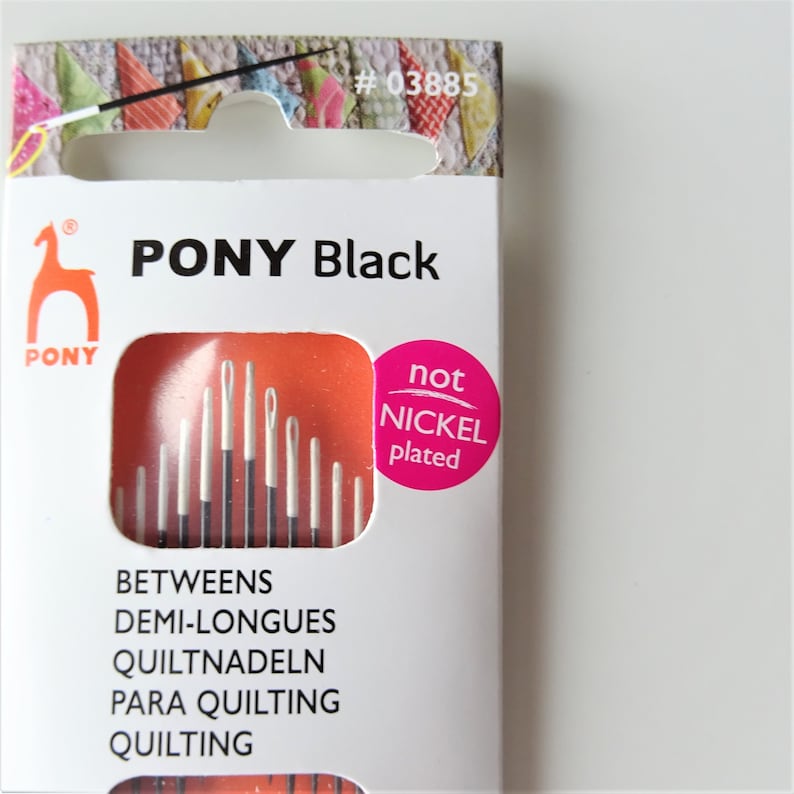 May include: A package of PONY Black quilting needles. The package is white with orange and pink accents. The needles are not nickel plated. The package includes the text "PONY Black" and "not nickel plated".