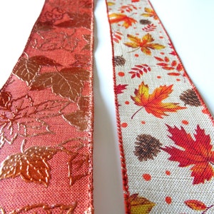 May include: Two rolls of autumn-themed ribbon. One roll is orange with a metallic gold leaf pattern. The other roll is beige with a brown hessian texture and a printed pattern of orange, red, and yellow leaves.