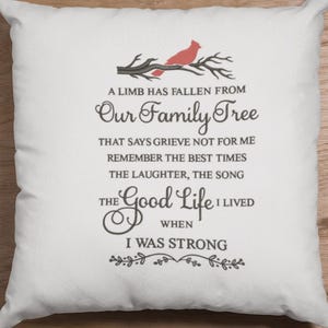 May include: A white throw pillow with a black embroidered quote that reads "A limb has fallen from our family tree that says grieve not for me remember the best times the laughter, the song the good life I lived when I was strong." A red cardinal is perched on a branch above the text.