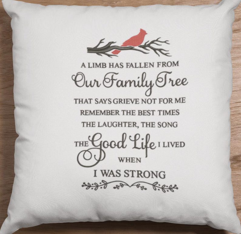 May include: A white throw pillow with a black embroidered quote that reads "A limb has fallen from our family tree that says grieve not for me remember the best times the laughter, the song the good life I lived when I was strong." A red cardinal is perched on a branch above the text.