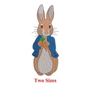 May include: Embroidered design of Peter Rabbit, a brown rabbit wearing a blue jacket, holding a carrot. The design is available in two sizes.