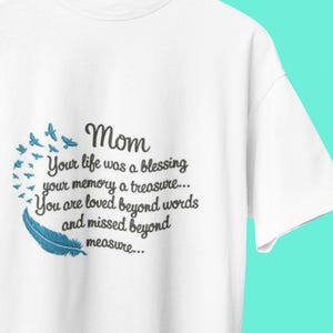 May include: White t-shirt with a black embroidered design that reads "Mom Your life was a blessing your memory a treasure... You are loved beyond words and missed beyond measure..." with a blue feather and blue birds.