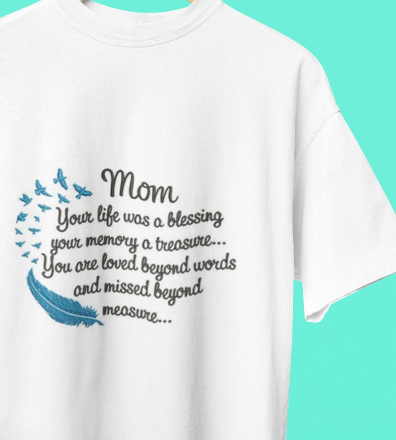 May include: White t-shirt with a black embroidered design that reads "Mom Your life was a blessing your memory a treasure... You are loved beyond words and missed beyond measure..." with a blue feather and blue birds.