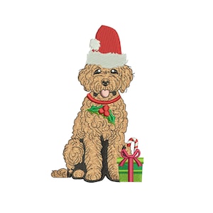 Puede incluir: Imagen bordada de un perro golden doodle con un gorro de Papá Noel rojo y un collar con acebo. Una caja de regalo verde con un lazo rojo y un bastón de caramelo están al lado del perro. La imagen está sobre un fondo blanco.