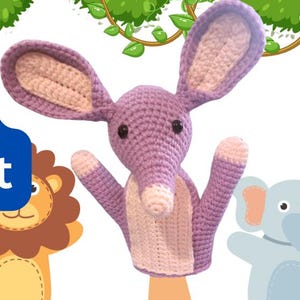 Könnte beinhalten: Gehäkelte lila Handpuppe eines Bilby mit langen Ohren und weißer Schnauze, mit dem Text "Bob Bilby Hand Puppet PDF" in einer blauen Box. Weitere Tierhandpuppen sind ebenfalls zu sehen, darunter ein Löwe und ein Elefant.