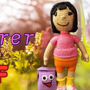 May include: A crocheted Dora the Explorer doll with a pink shirt, orange shorts, and yellow boots. A purple backpack with a smiling face sits beside her. The image includes the text "Dora the Explorer PDF".