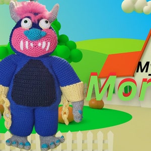 May include: A blue crocheted monster with pink hair and a toothy grin stands in front of a white house with an orange roof. The text "My Pet Monster" is in green and red letters in front of the house. There are orange pumpkins in the grass.