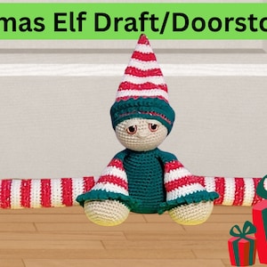 May include: A crocheted Christmas elf doorstop with red and white striped legs and a green hat. The elf is sitting on a wooden floor with three red and green wrapped presents in front of it.