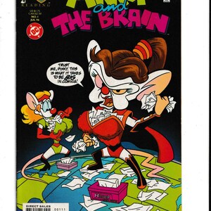 May include: A Pinky and the Brain comic book issue number one from July 1996. The cover features the two cartoon mice characters standing on a globe, surrounded by scattered papers. The Brain wears a red costume, and the text reads: TRUST ME, PINKY, THIS IS WHAT IT TAKES TO BE BIG IN COMICS!