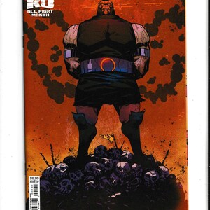 May include: Comic book cover for "Superman vs. Captain Atom #1" featuring a muscular figure standing on a pile of skulls. The figure is dark-skinned with a black outfit and a belt with a red Omega symbol. The background is orange with dark smoke-like shapes.