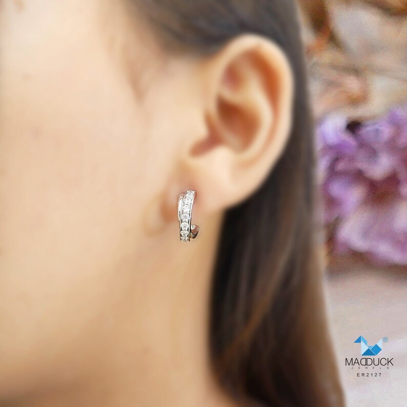 May include: Silver hoop earrings with a row of small clear cubic zirconia stones.