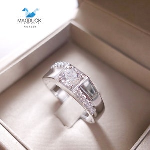 May include: A silver ring with a single large diamond in a square setting. The ring is surrounded by smaller diamonds. The ring is in a white box with the text "MADDUCK JEWEL RG1559".