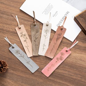 May include: Five leather bookmarks with floral designs and personalized names. The names are "Justice", "Amelia", "Audrey", "To tell you the truth", and "Blooming".