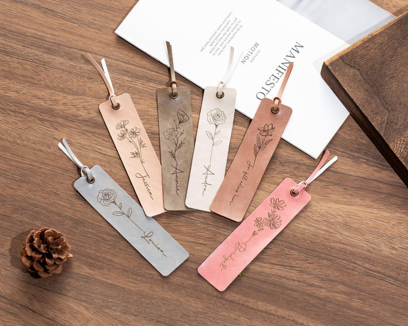 May include: Five leather bookmarks with floral designs and personalized names. The names are "Justice", "Amelia", "Audrey", "To tell you the truth", and "Blooming".