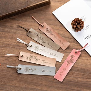 May include: Six leather bookmarks with floral designs and personalized names. The bookmarks are in shades of brown and pink with white string.