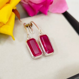 Könnte beinhalten: Ein Paar silberne Ohrhänger mit rechteckigen rosafarbenen Edelsteinen.