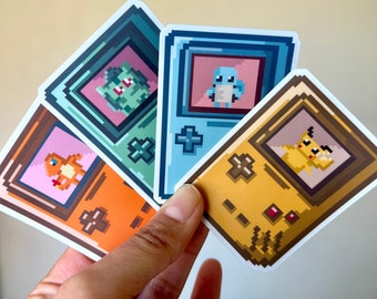 Könnte beinhalten: Vier Pixel-Art-Aufkleber mit verschiedenen Pokémon-Charakteren. Jeder Aufkleber hat die Form einer tragbaren Spielkonsole mit einem Bildschirm, auf dem das Pokémon angezeigt wird. Die Pokémon sind Bisasam, Schiggy, Glumanda und Pikachu.