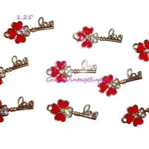 Puede incluir: Ocho dijes de llave de tono dorado con diseños de trébol de cuatro hojas de esmalte rojo y diamantes de imitación transparentes. Cada dije tiene la palabra "love" inscrita en la llave. Los dijes miden 1,25 pulgadas.