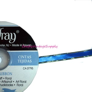 Könnte beinhalten: Eine Spule blauen Satinbandes mit goldener Einfassung. Das Band liegt auf weißem Hintergrund. Die Spule ist mit "CINTAS TEJIDAS" und "CA 07795" beschriftet.