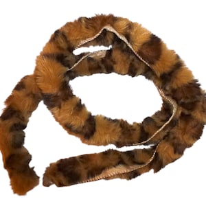 May include: A long, brown and black faux fur trim with a leopard print pattern.