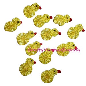 May include: Ten yellow felt duckling embellishments with red beaks. The ducklings are approximately 1 inch in size.