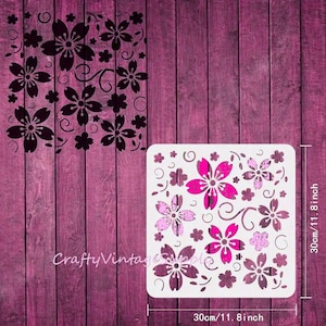 Peut inclure: Pochoir en plastique blanc avec un motif répété de fleurs de cerisier roses et de volutes. Le pochoir mesure 30 cm sur 30 cm.