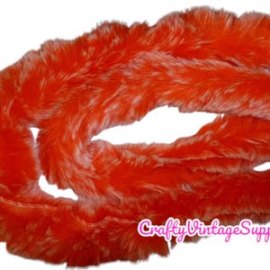 May include: Orange and white faux fur trim. The fur is long and fluffy, with a shaggy texture.