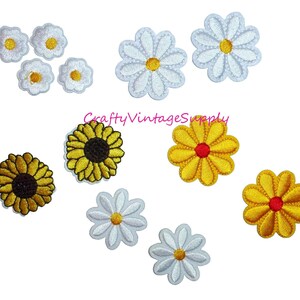 May include: Assortment of iron-on flower patches in white, yellow, and red. The patches feature daisy and sunflower designs.