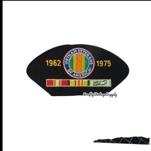 May include: A black, fan-shaped embroidered patch featuring the text 1962 and 1975 in yellow. A central circular emblem reads Vietnam Veterans of America with a yellow, green, and red striped centre. A multi-coloured ribbon bar sits below the emblem.