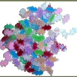 May include: A collection of colorful, translucent plastic charms in various shapes, including jellyfish, butterflies, and leaves. The charms are in shades of pink, purple, green, and blue, with some iridescent elements.