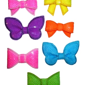 May include: Seven colourful sequined bows in various shapes and sizes. The bows are pink, yellow, purple, orange, blue, and green.